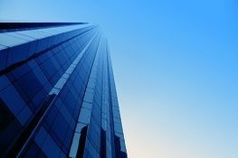 Un rascacielos alto que se eleva hacia un cielo azul.