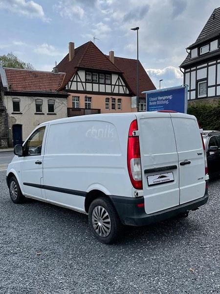 Ein weißer Lieferwagen steht vor einem Gebäude