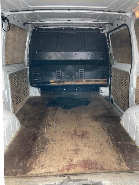 Das Innere eines leeren Lieferwagens mit Holzboden.