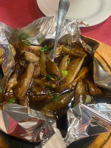 Un primer plano de un plato de comida con una cuchara sobre una mesa.