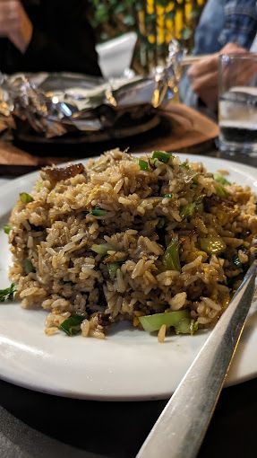 Un primer plano de un plato de comida con arroz y verduras en una mesa.