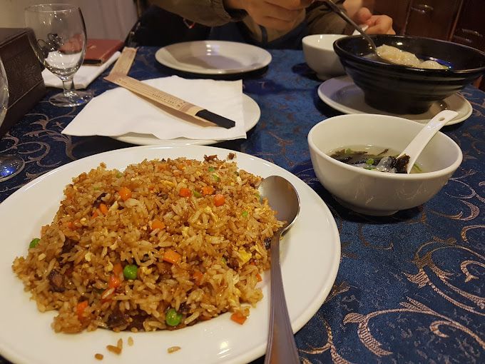Un plato de arroz frito y un tazón de sopa en una mesa