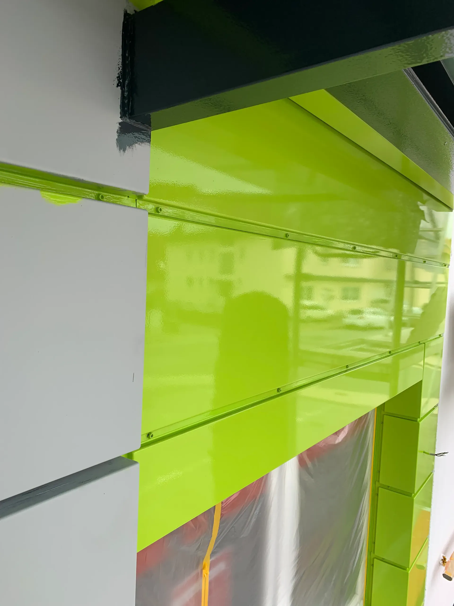 Eine Nahaufnahme eines grün-weißen Gebäudes mit einem Fenster.