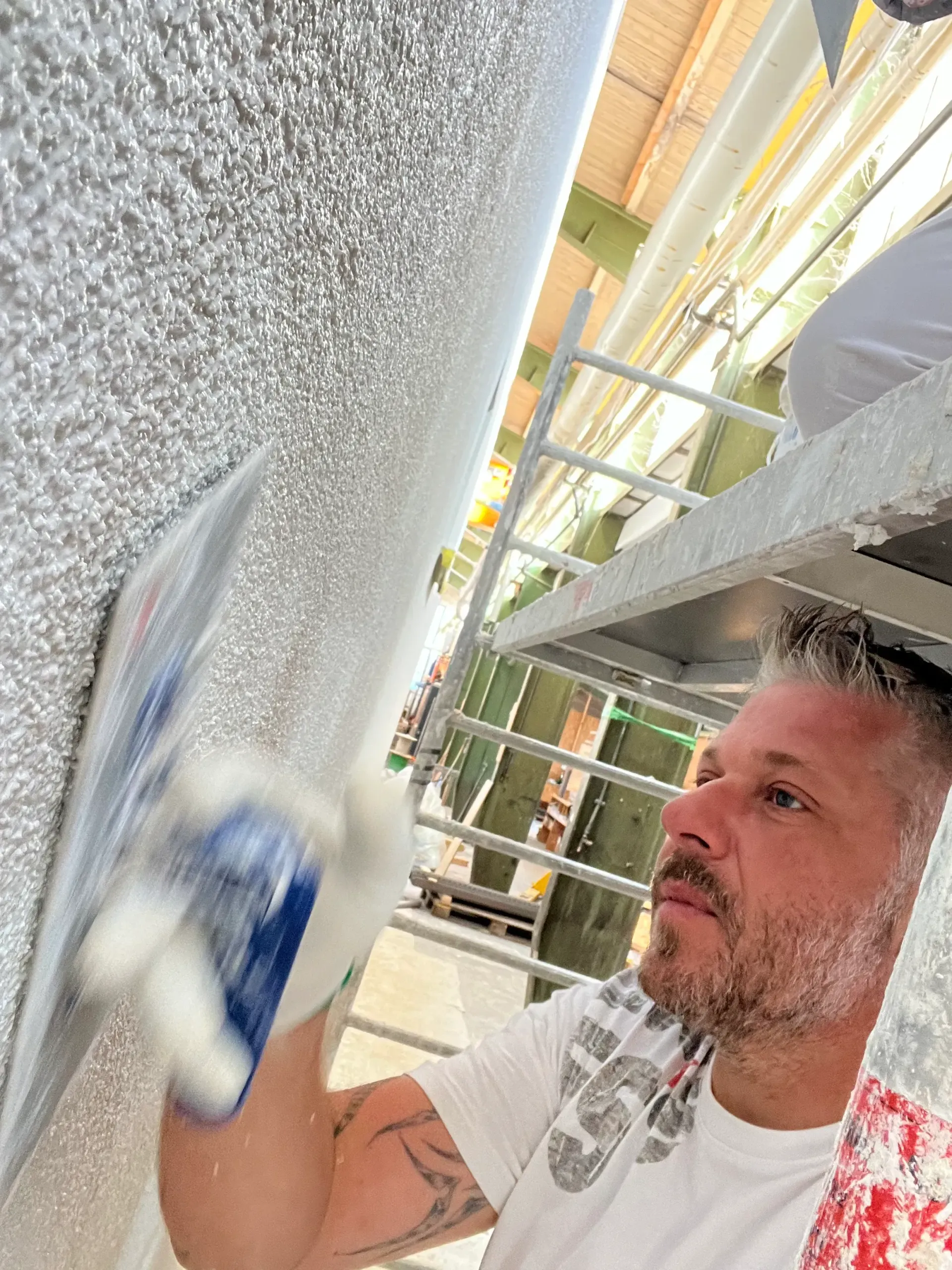 Ein Mann verputzt eine Wand mit einer Kelle.