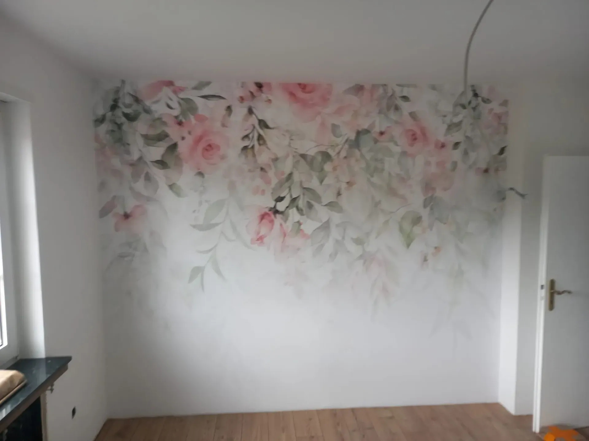 Ein Zimmer mit einer großen Blumentapete an der Wand.