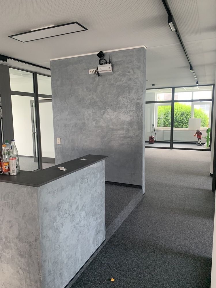 In der Mitte des Raumes hängt ein Projektor an der Wand.