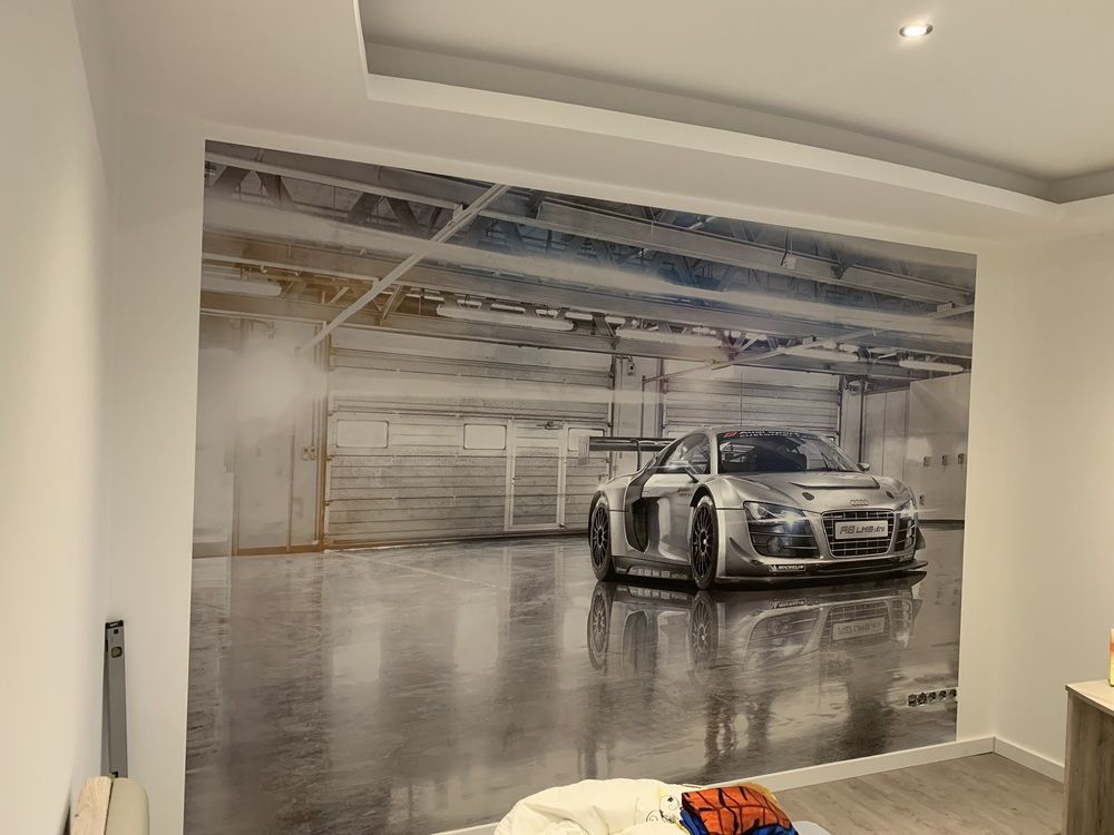Ein Schlafzimmer mit einem Bild von einem Auto an der Wand.