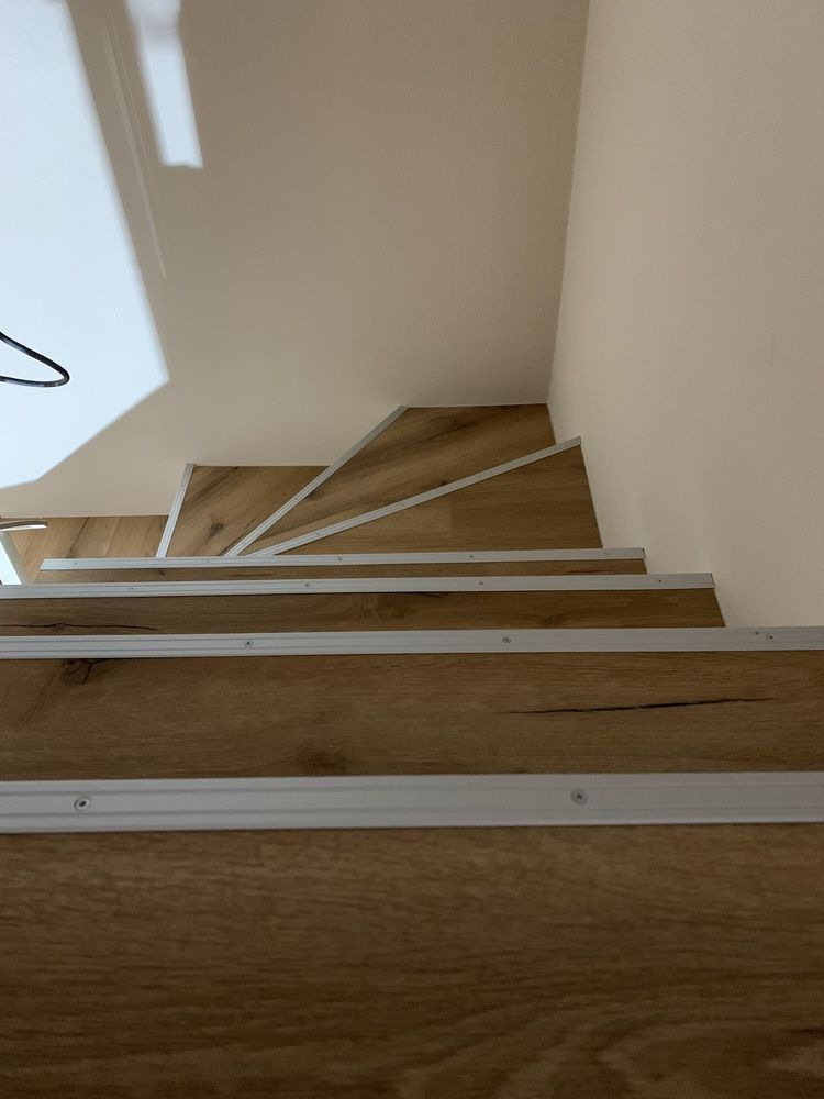 Eine Nahaufnahme einer Holztreppe mit weißem Rand.