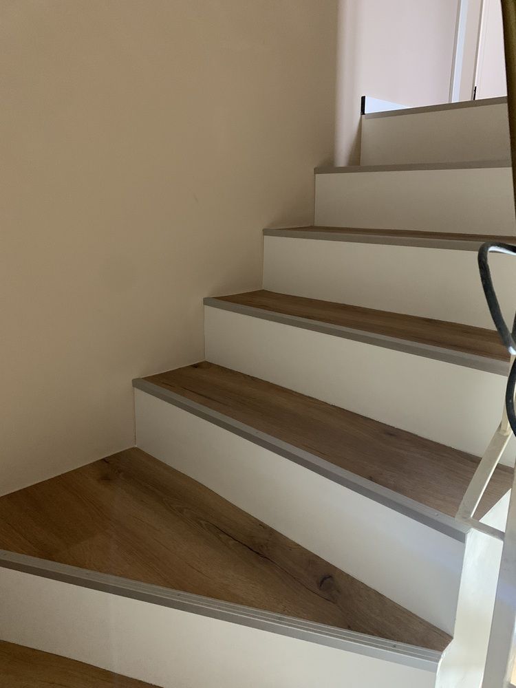 Eine weiße Treppe mit Holzstufen und einem Metallgeländer.