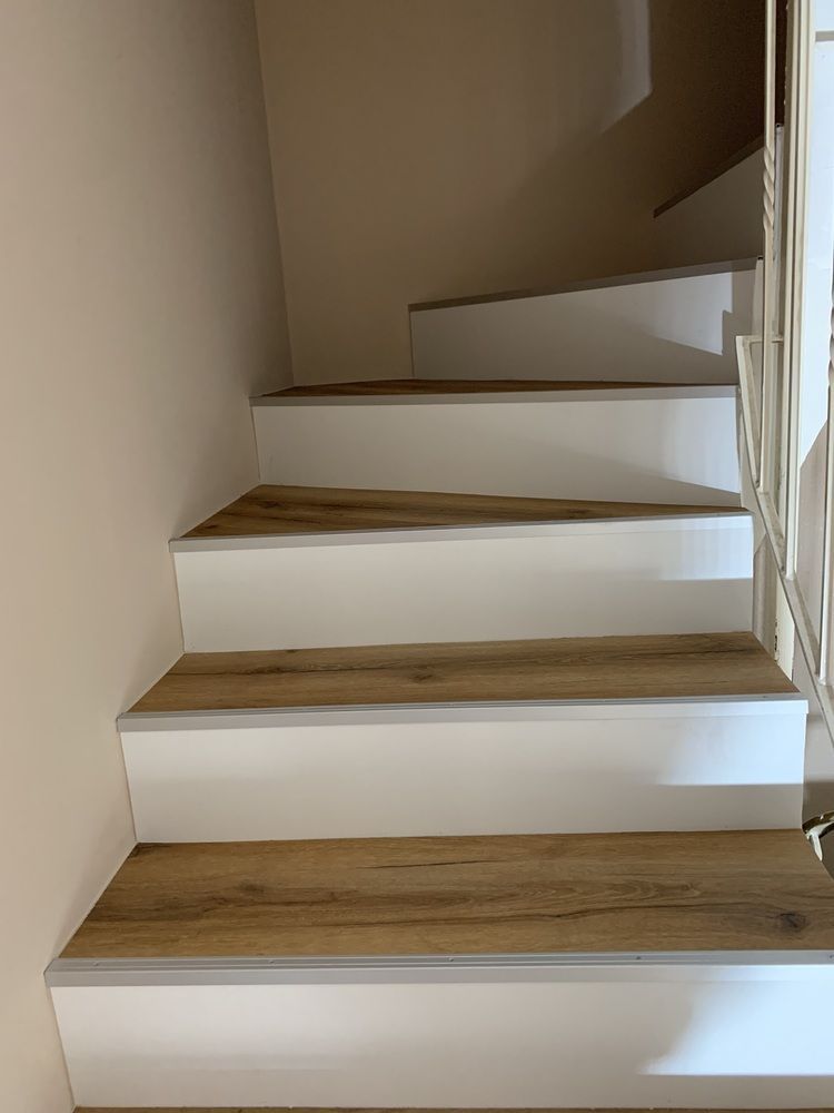 Eine Treppe mit Holzstufen und einem weißen Geländer.