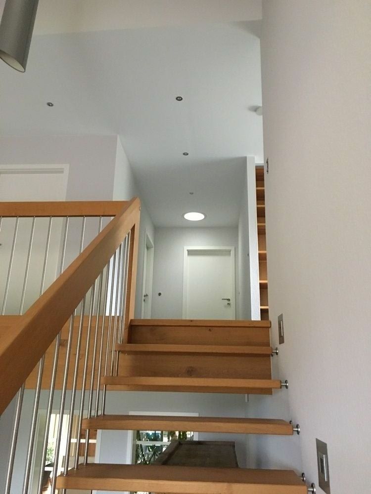 Eine Holztreppe mit Metallgeländer, die in den zweiten Stock führt