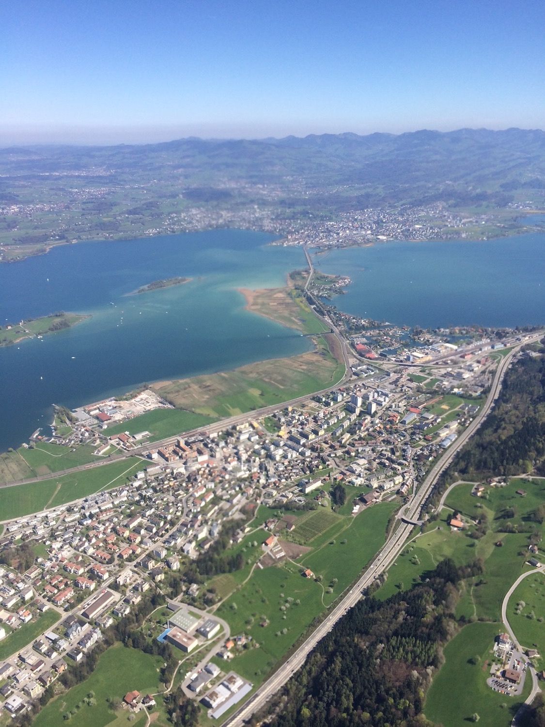 Eine Luftaufnahme einer Stadt, die von Wasser und Bergen umgeben ist.