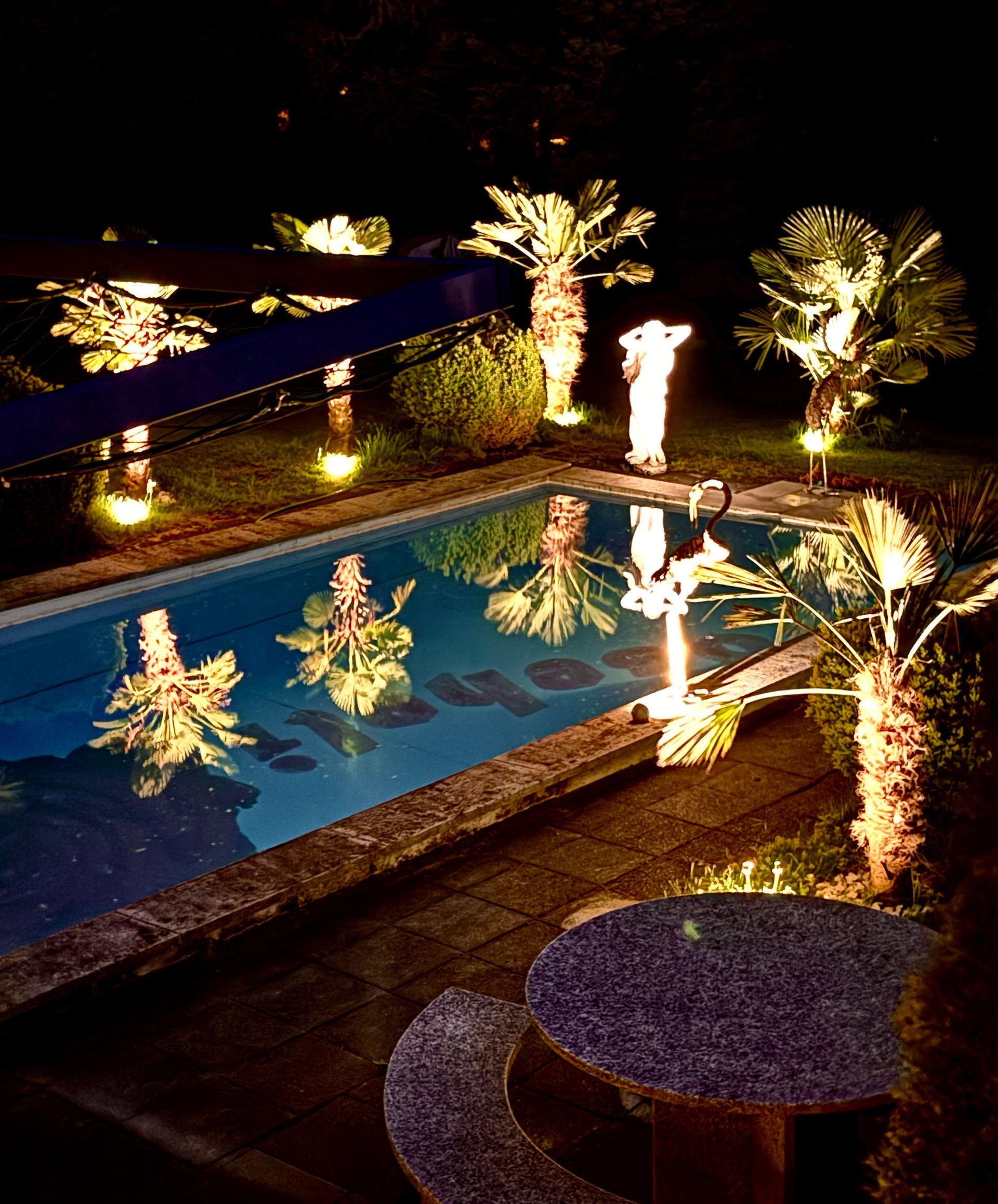 Ein großes Schwimmbad ist nachts beleuchtet