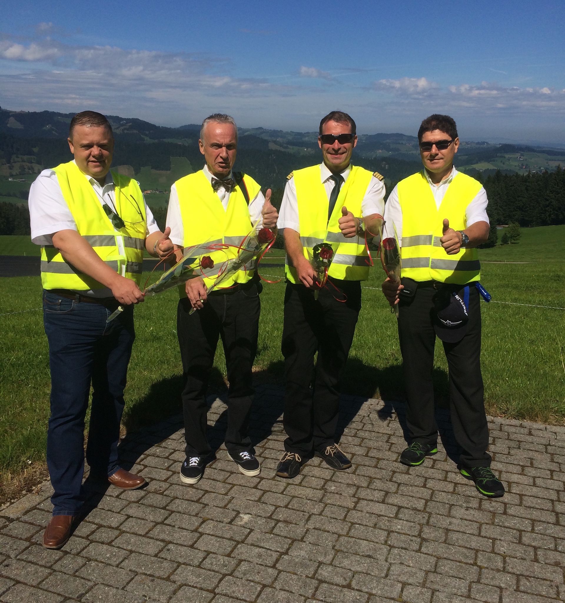 Eine Gruppe von Männern in gelben Westen steht auf einem Bürgersteig