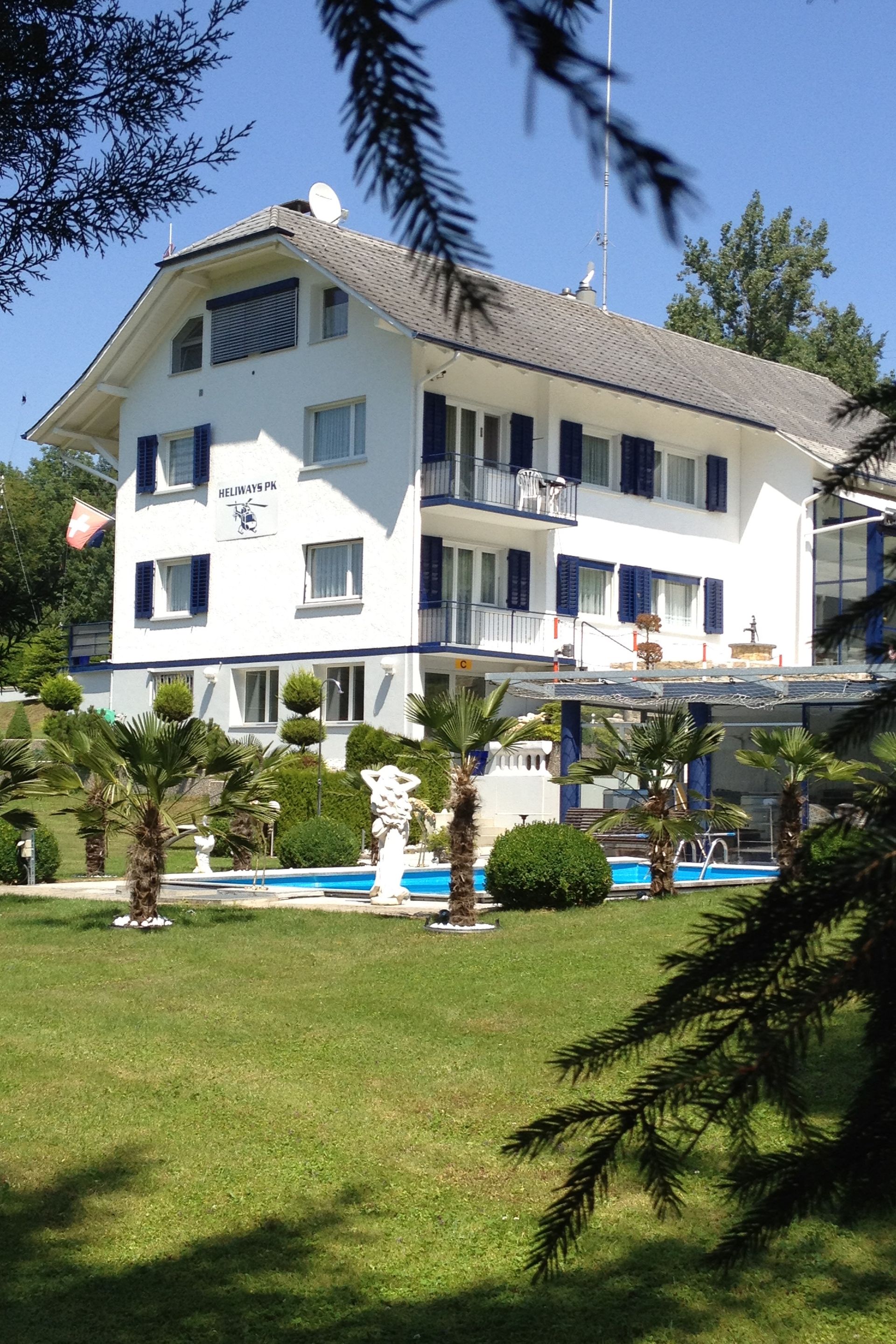 Ein großes weißes Haus mit einem Swimmingpool davor