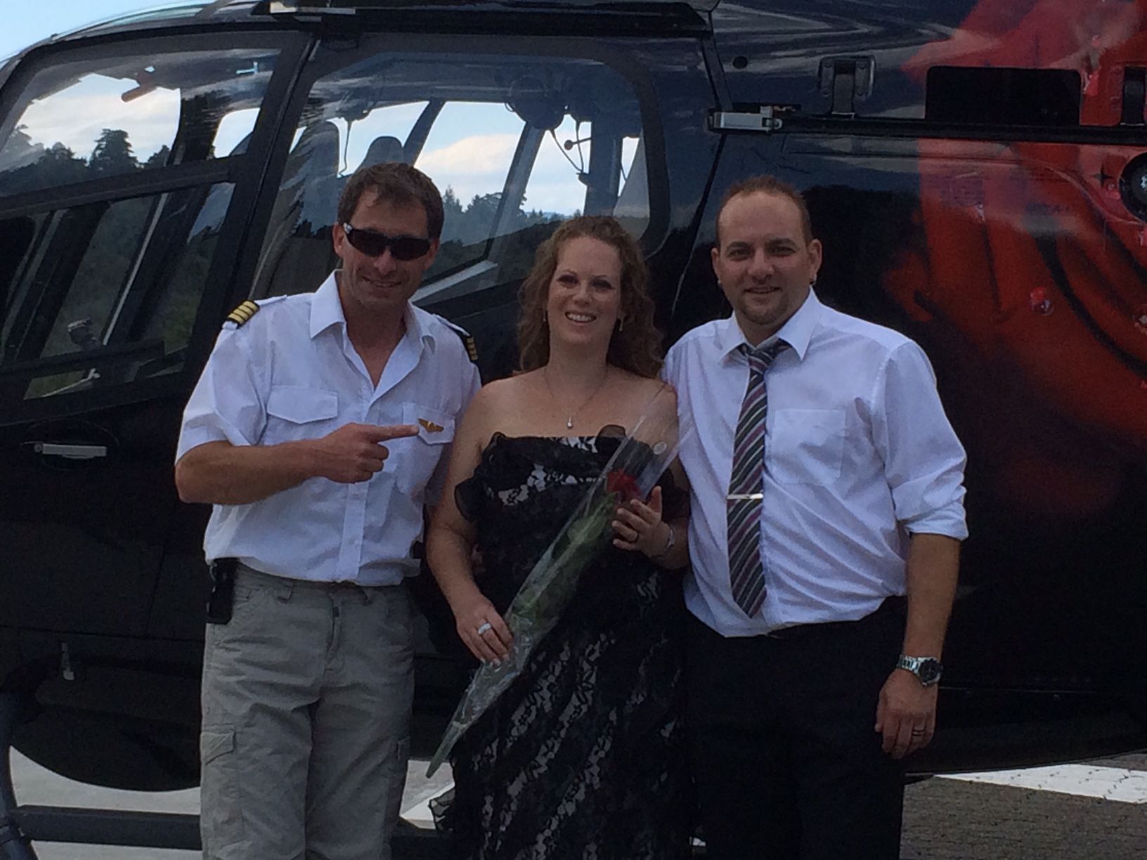 Paar mit einem Piloten vor Helikopter