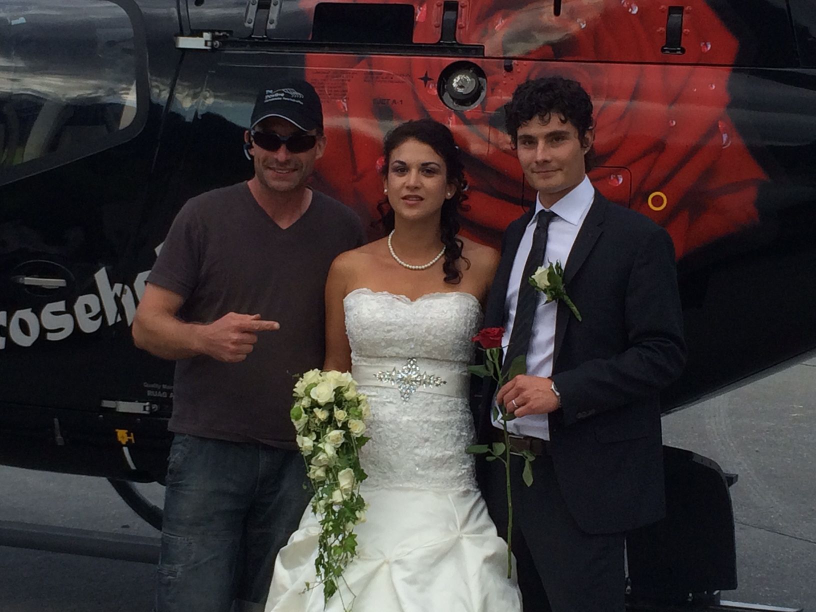 Braut und Bräutigam posieren für ein Foto vor einem Hubschrauber