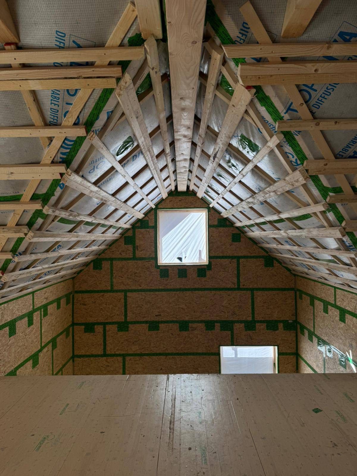 Eine Baustelle mit einem Kran, der ein Stück Holz anhebt, Zimmerei Patrick Pfaff