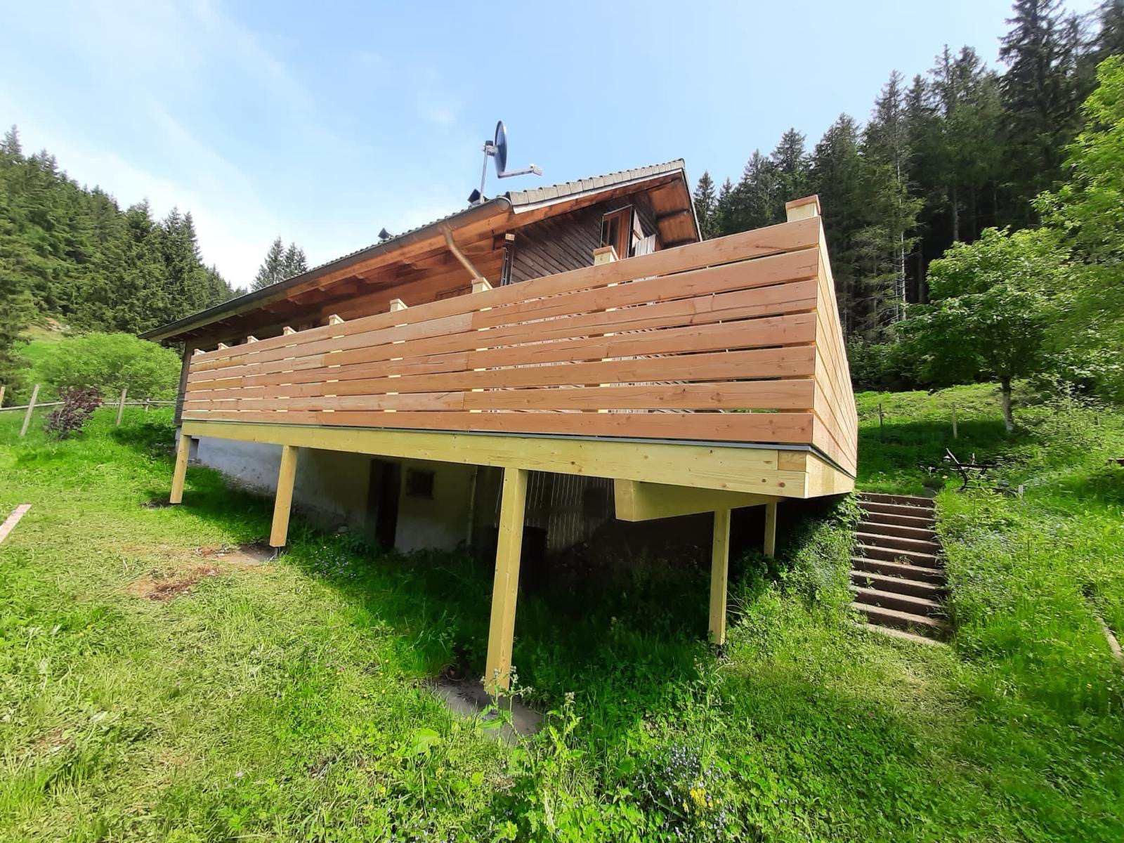 Eine Baustelle mit einem Kran, der ein Stück Holz anhebt, Zimmerei Patrick Pfaff
