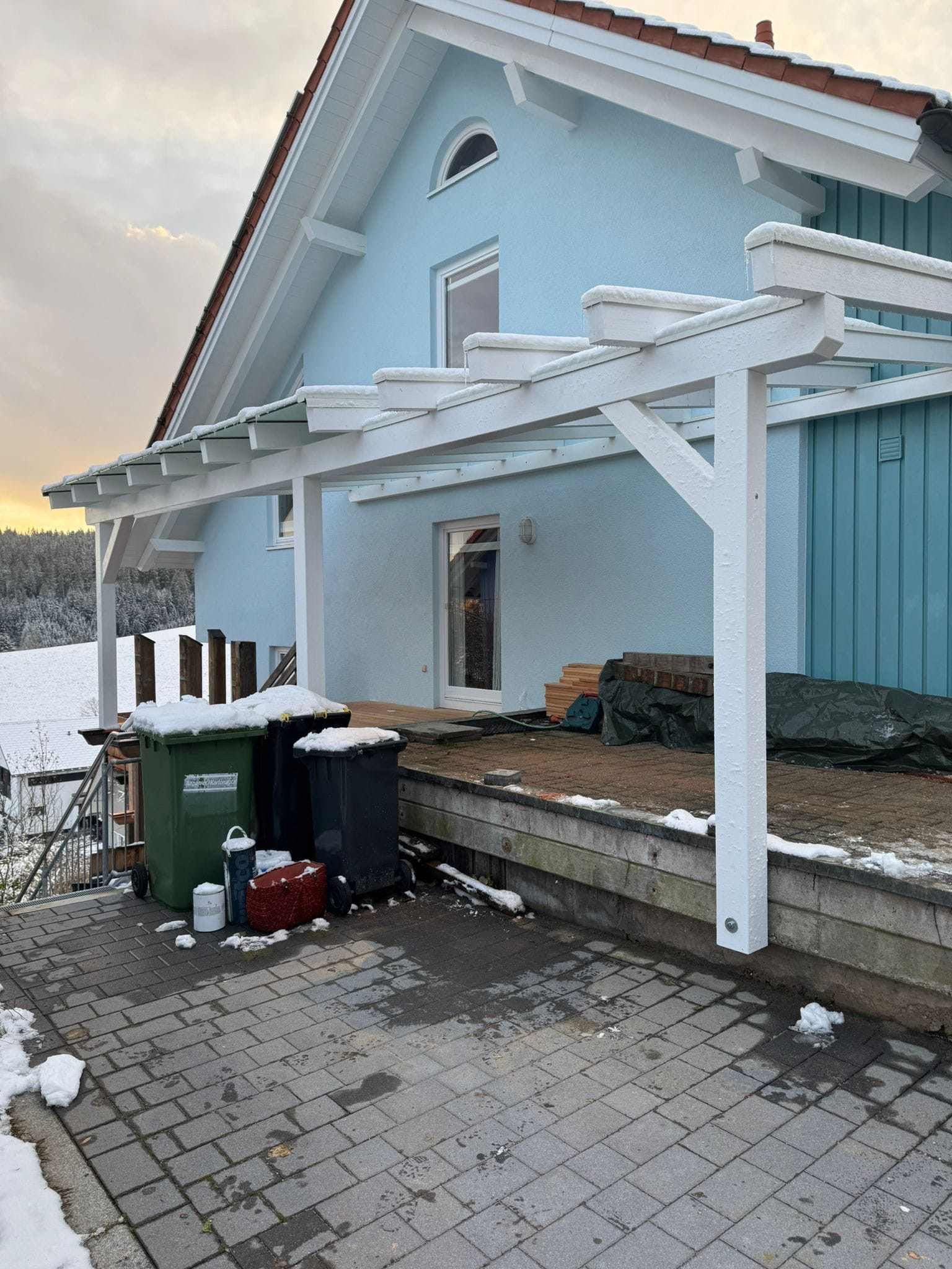 Eine Baustelle mit einem Kran, der ein Stück Holz anhebt, Zimmerei Patrick Pfaff