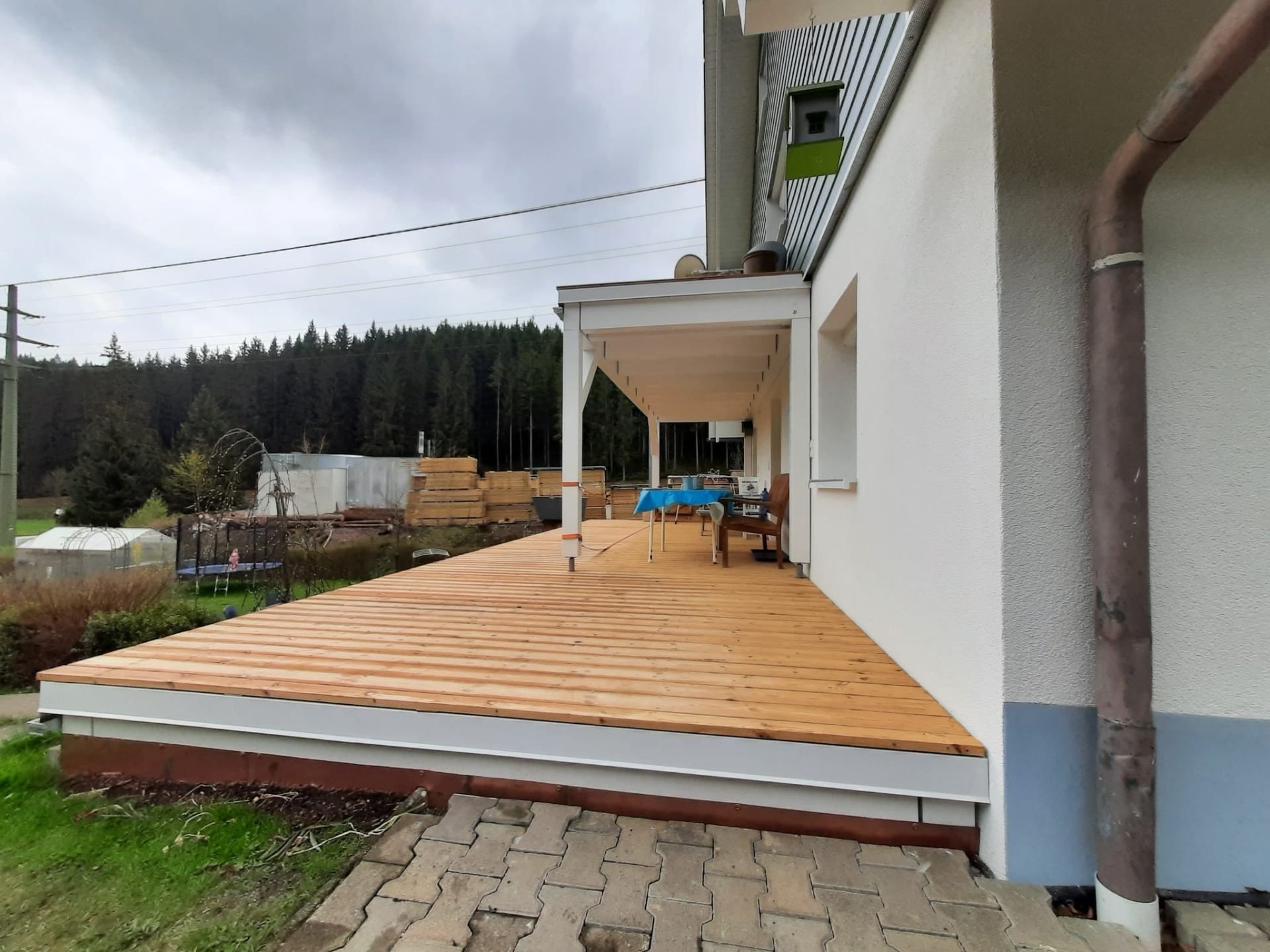 Eine Baustelle mit einem Kran, der ein Stück Holz anhebt, Zimmerei Patrick Pfaff