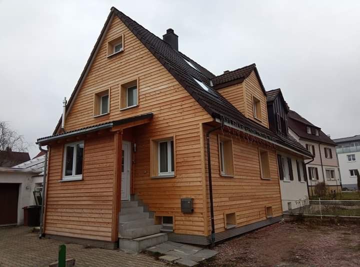 Eine Baustelle mit einem Kran, der ein Stück Holz anhebt, Zimmerei Patrick Pfaff