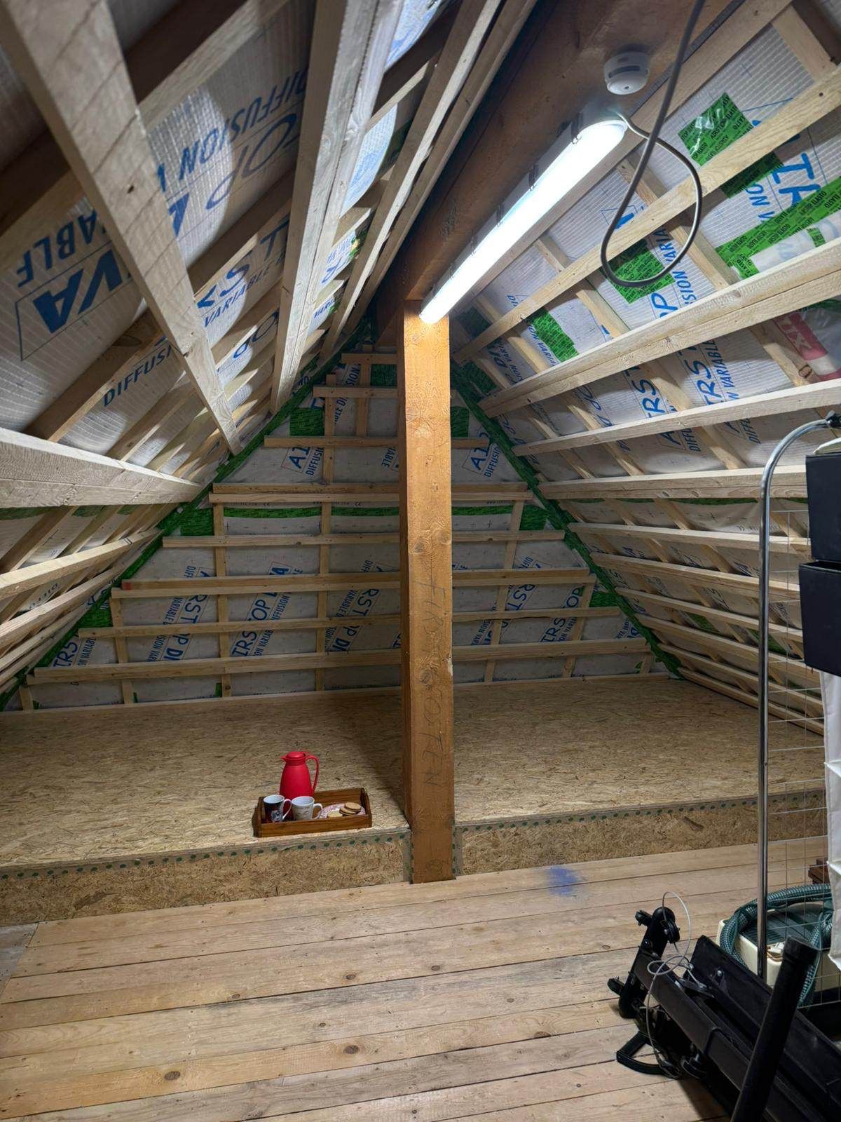 Eine Baustelle mit einem Kran, der ein Stück Holz anhebt, Zimmerei Patrick Pfaff