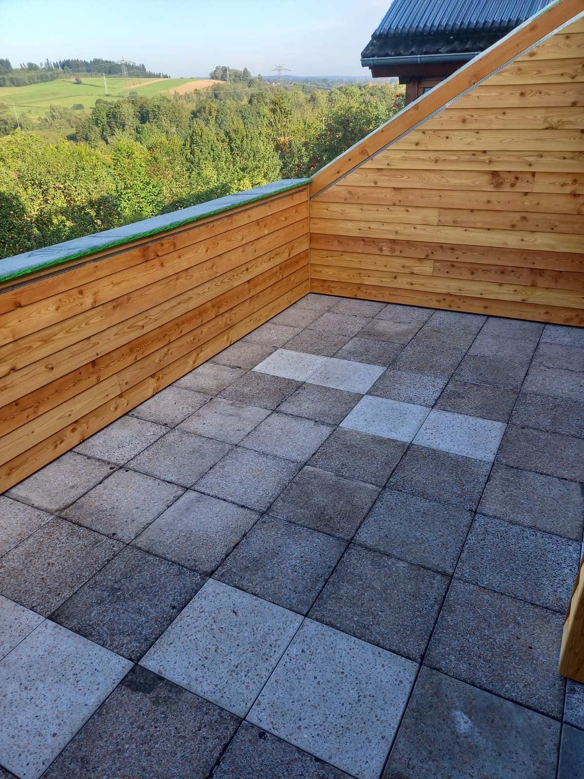 Eine Baustelle mit einem Kran, der ein Stück Holz anhebt, Zimmerei Patrick Pfaff