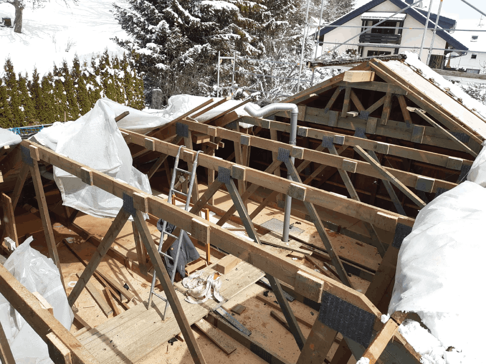 Das Dach eines Hauses wird gebaut und mit Schnee bedeckt, Zimmerei Patrick Pfaff