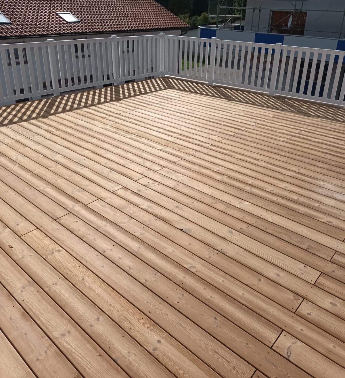 Eine Baustelle mit einem Kran, der ein Stück Holz anhebt, Zimmerei Patrick Pfaff