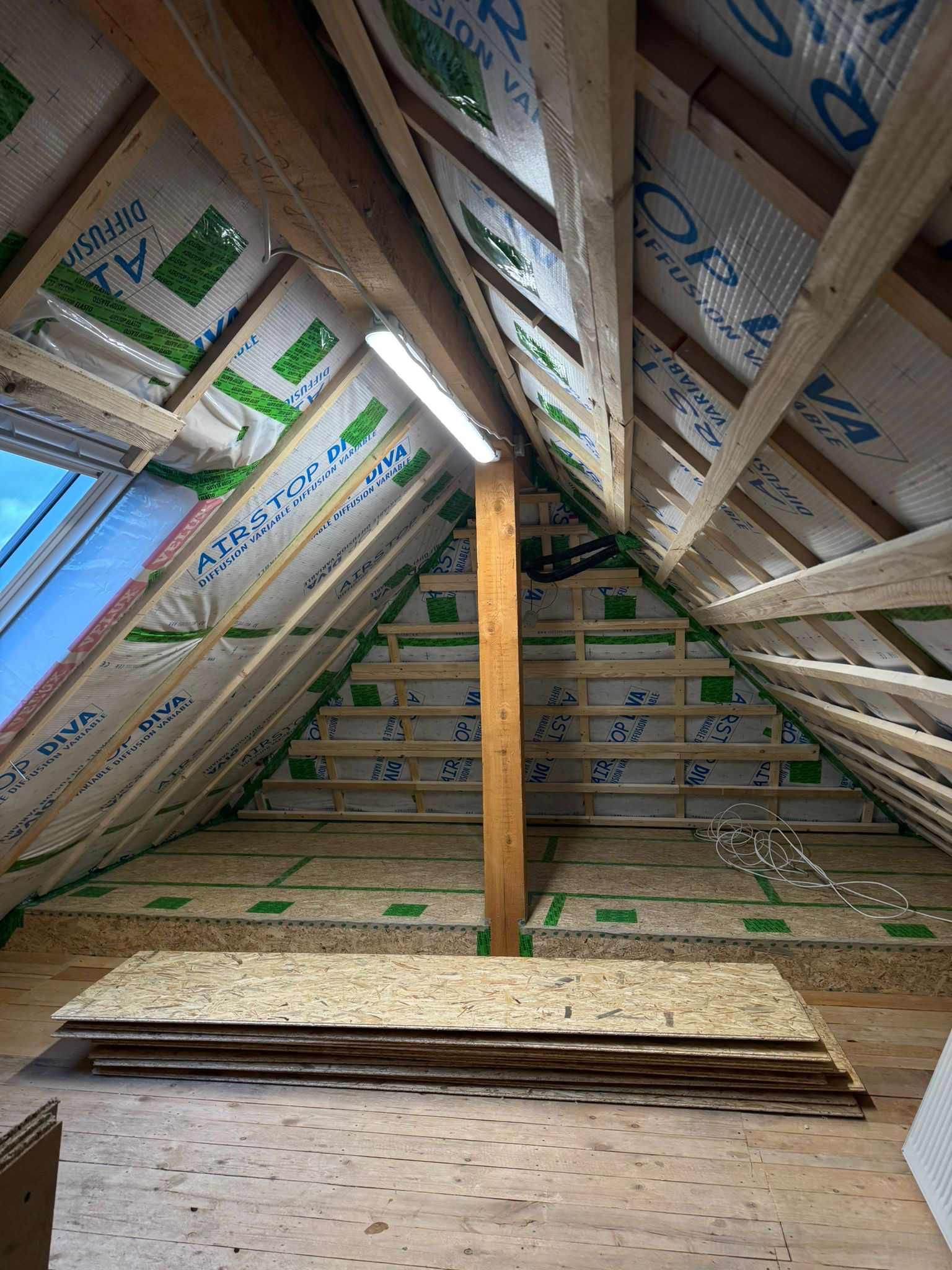 Eine Baustelle mit einem Kran, der ein Stück Holz anhebt, Zimmerei Patrick Pfaff