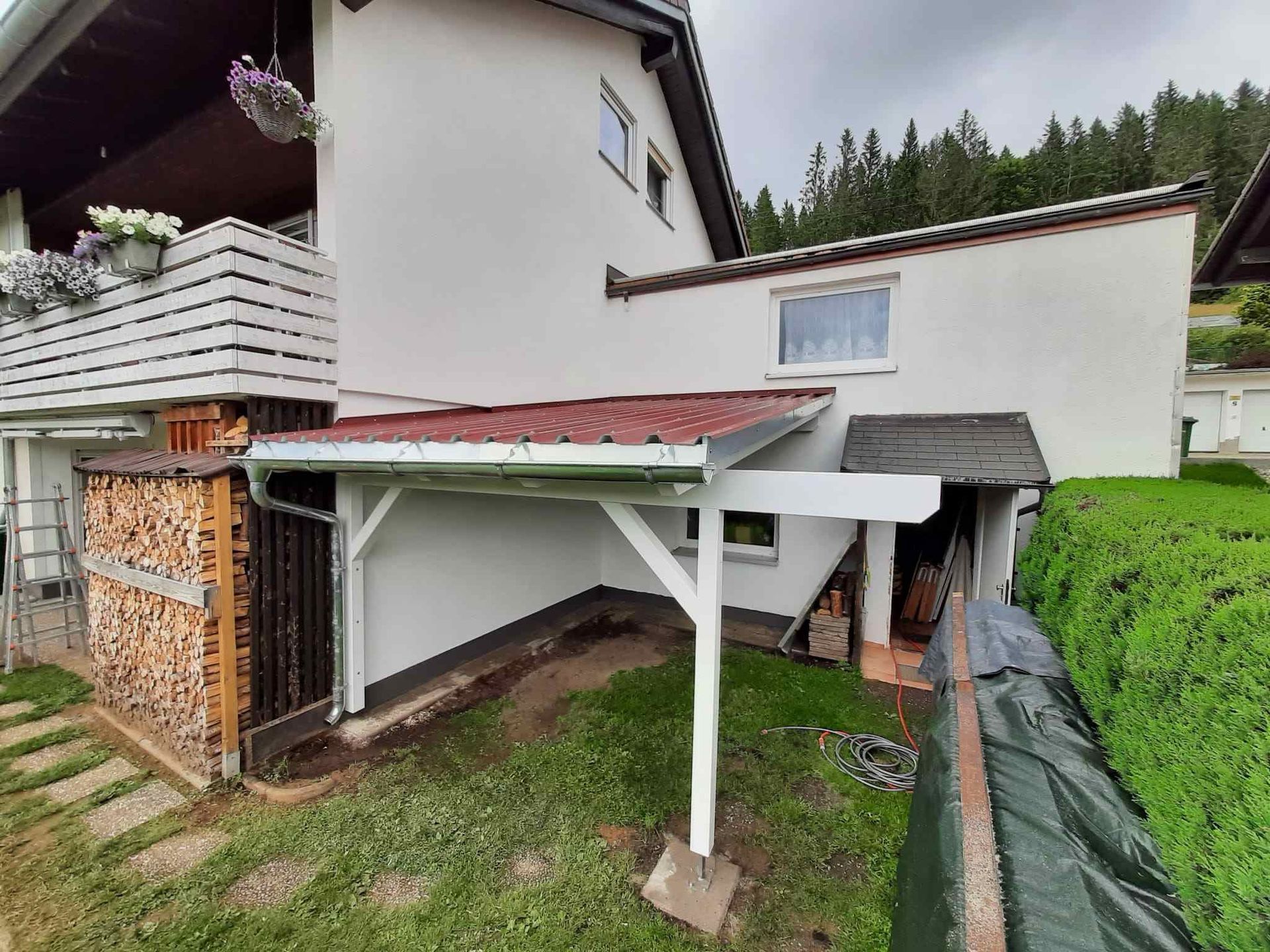 Eine Baustelle mit einem Kran, der ein Stück Holz anhebt, Zimmerei Patrick Pfaff