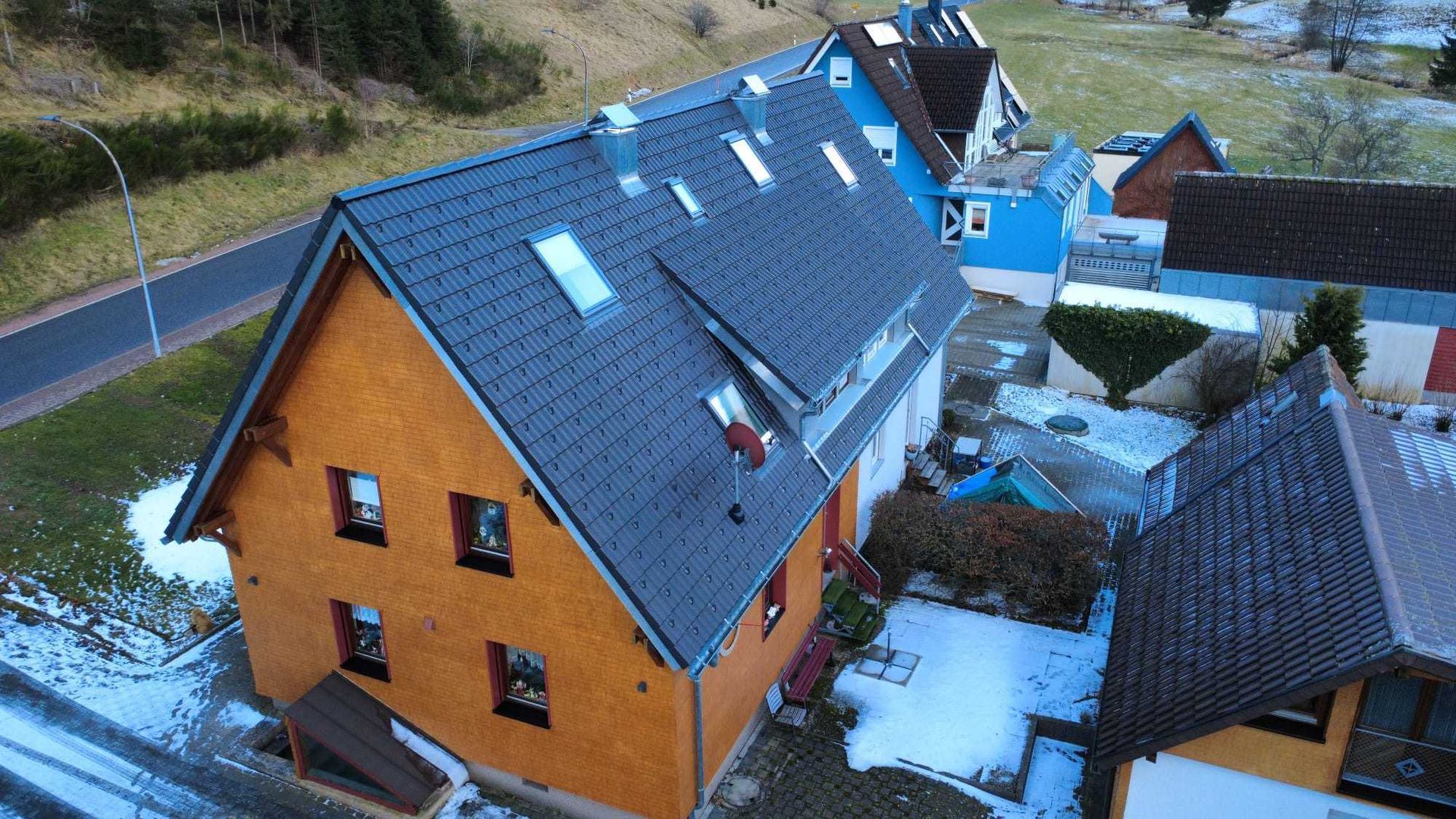 Eine Baustelle mit einem Kran, der ein Stück Holz anhebt, Zimmerei Patrick Pfaff