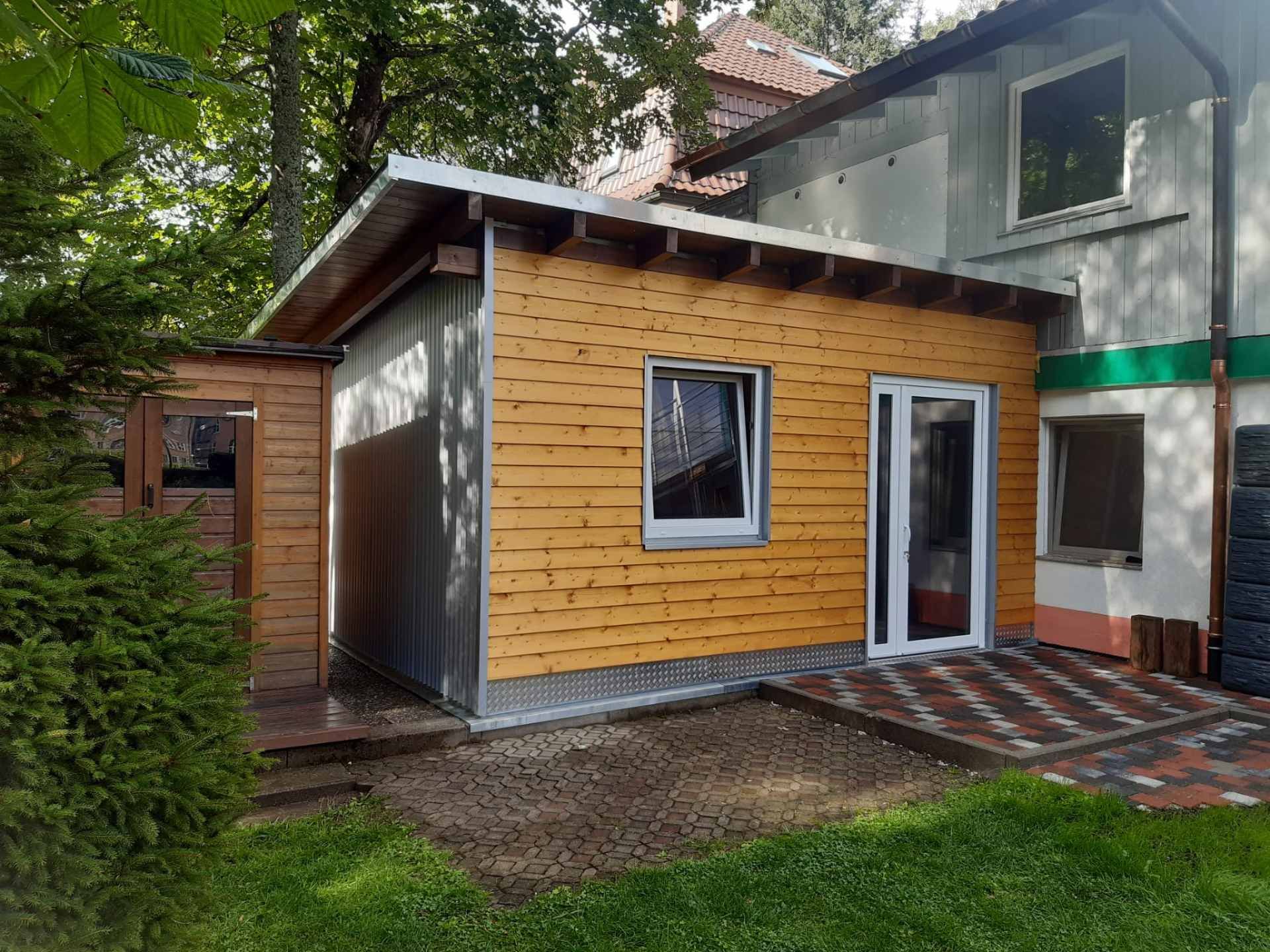 Eine Baustelle mit einem Kran, der ein Stück Holz anhebt, Zimmerei Patrick Pfaff