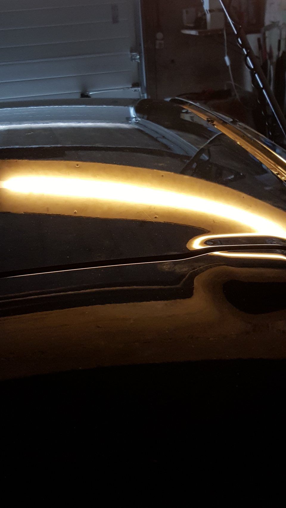 Eine Nahaufnahme der Motorhaube eines Autos in einer Garage.