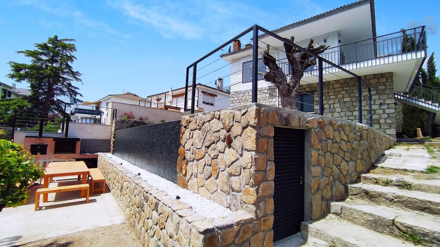 Un muro de piedra con escaleras que conducen a una casa.