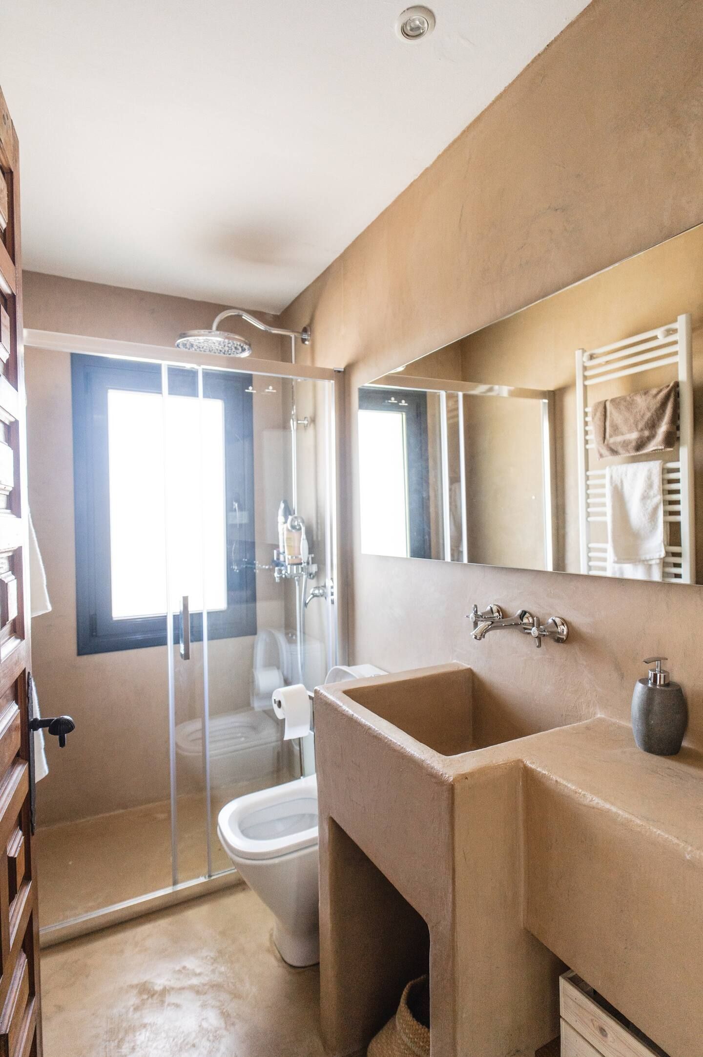 Un baño con lavabo, inodoro, ducha y espejo.