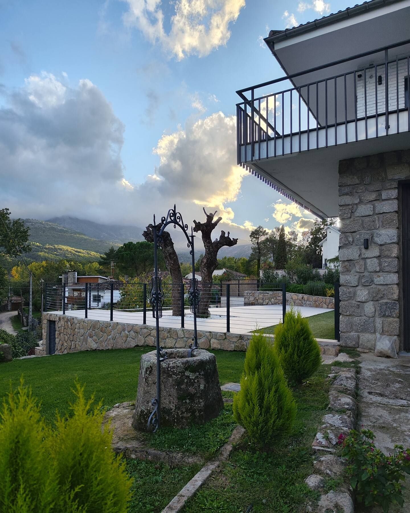 Una casa con un balcón con vista a un exuberante campo verde.