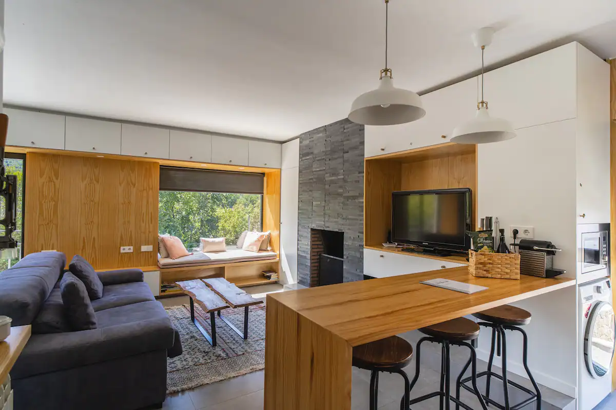 Una sala de estar con sofá, mesa y televisión.