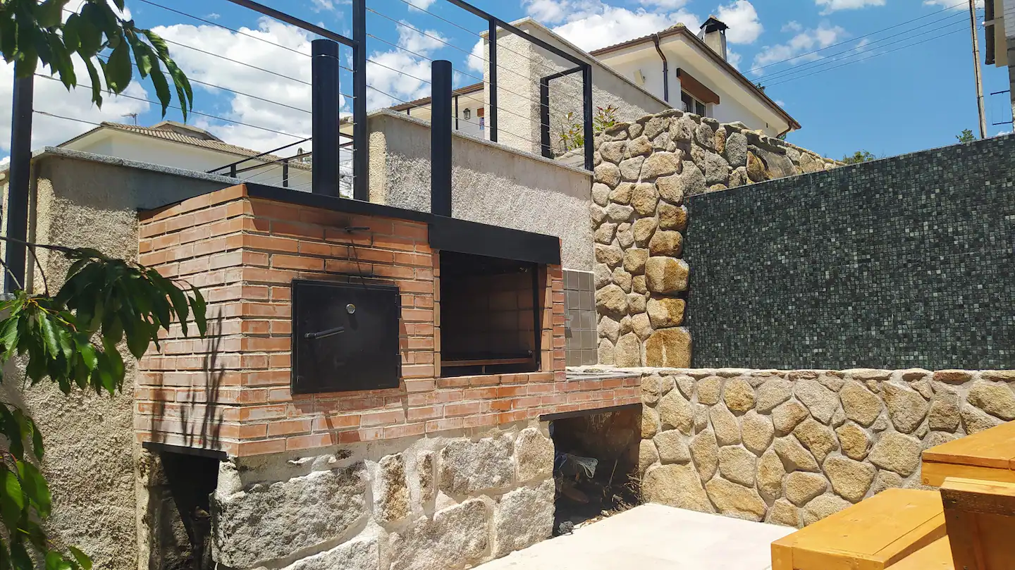 Hay un horno de ladrillos en el patio trasero de una casa.