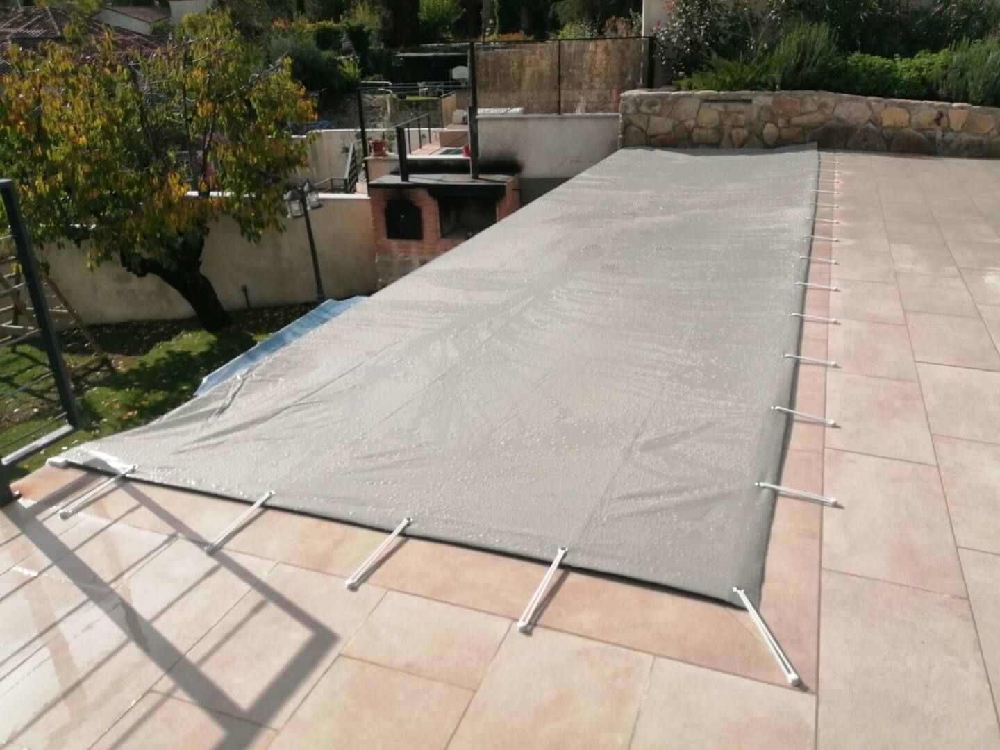 Una gran lona gris cubre una piscina.