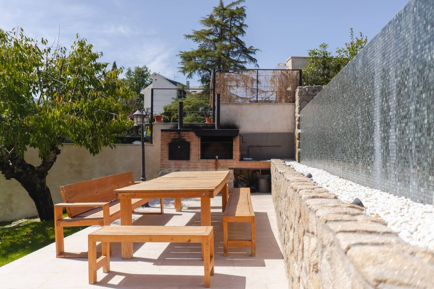 Una mesa de picnic de madera y bancos en un patio trasero.