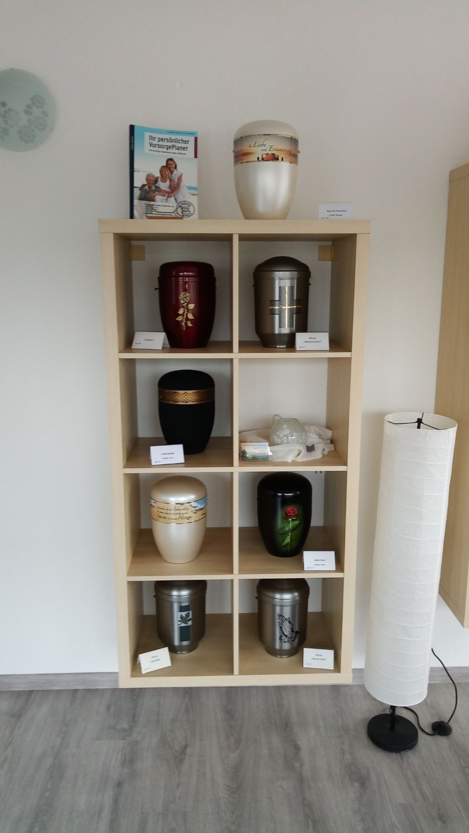 verschiedene verzierte Urnen in einem Regal