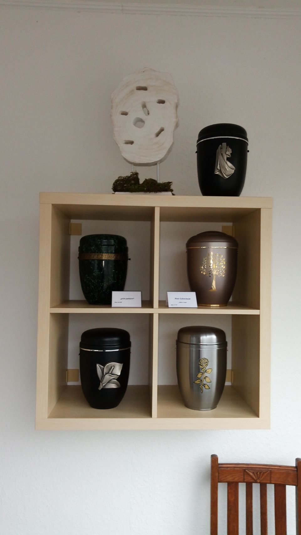 fünf edle Urnen mit Verzierungen in einem Regal