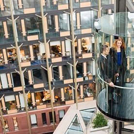 Un grupo de personas están paradas en un ascensor frente a un edificio.