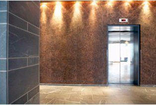 Un ascensor está parado en medio de un pasillo en un edificio.