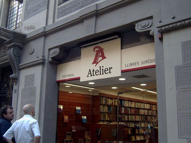 Exterior de la librería Atelier con personas, logo rojo y blanco y libros legales.