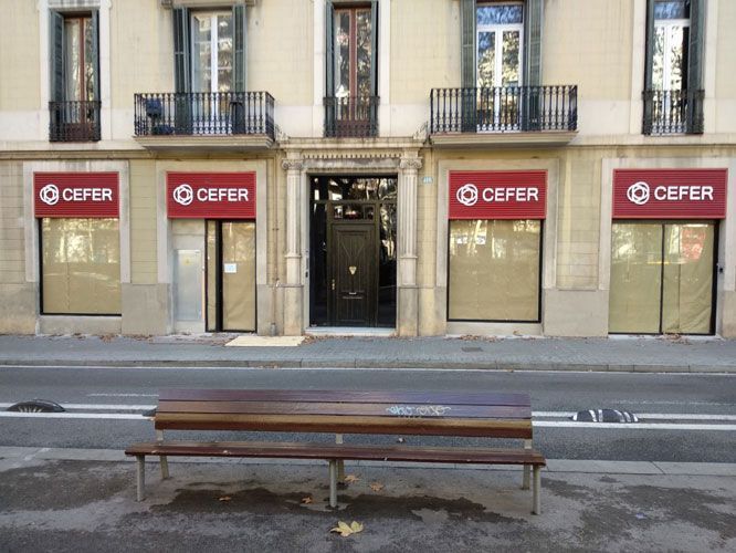 Banco frente a un edificio con letreros y ventanas de