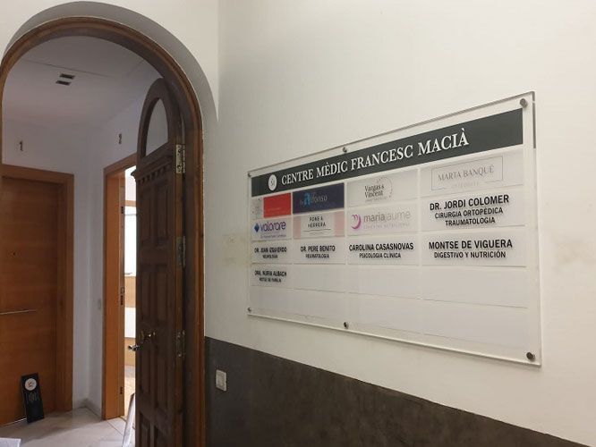 Cartel del Centro Médico Francesc Macià, con una lista de profesionales médicos y sus especialidades en un pasillo.
