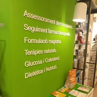 Pared verde en farmacia con texto blanco que lista servicios: asesoramiento dermocosmético, seguimiento farmacéutico, preparación de medicamentos, terapias naturales, glucosa/colesterol y dietética/nutrición.